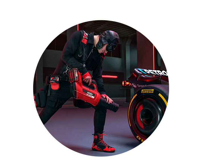 A man cools the brakes of a car with a battery-powered leaf blower