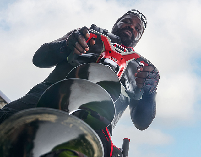 an e team worker working with a cordless auger